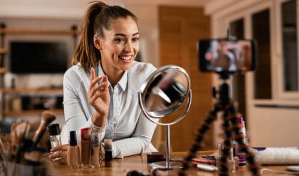 Smiling female influencer talking about beauty products while vlogging from home. Learn how influencers working
