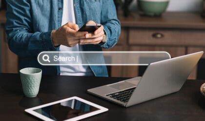 Man using cell phone and notebook to check domain authority